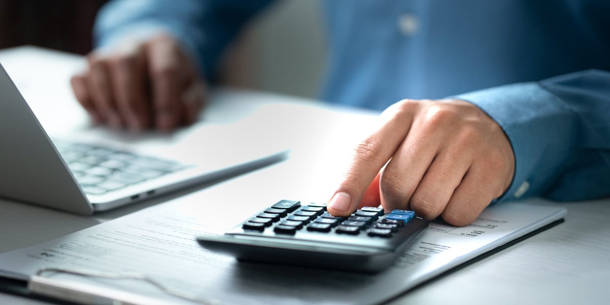 Análisis fiscal digital en laptop con calculadora y documentos
